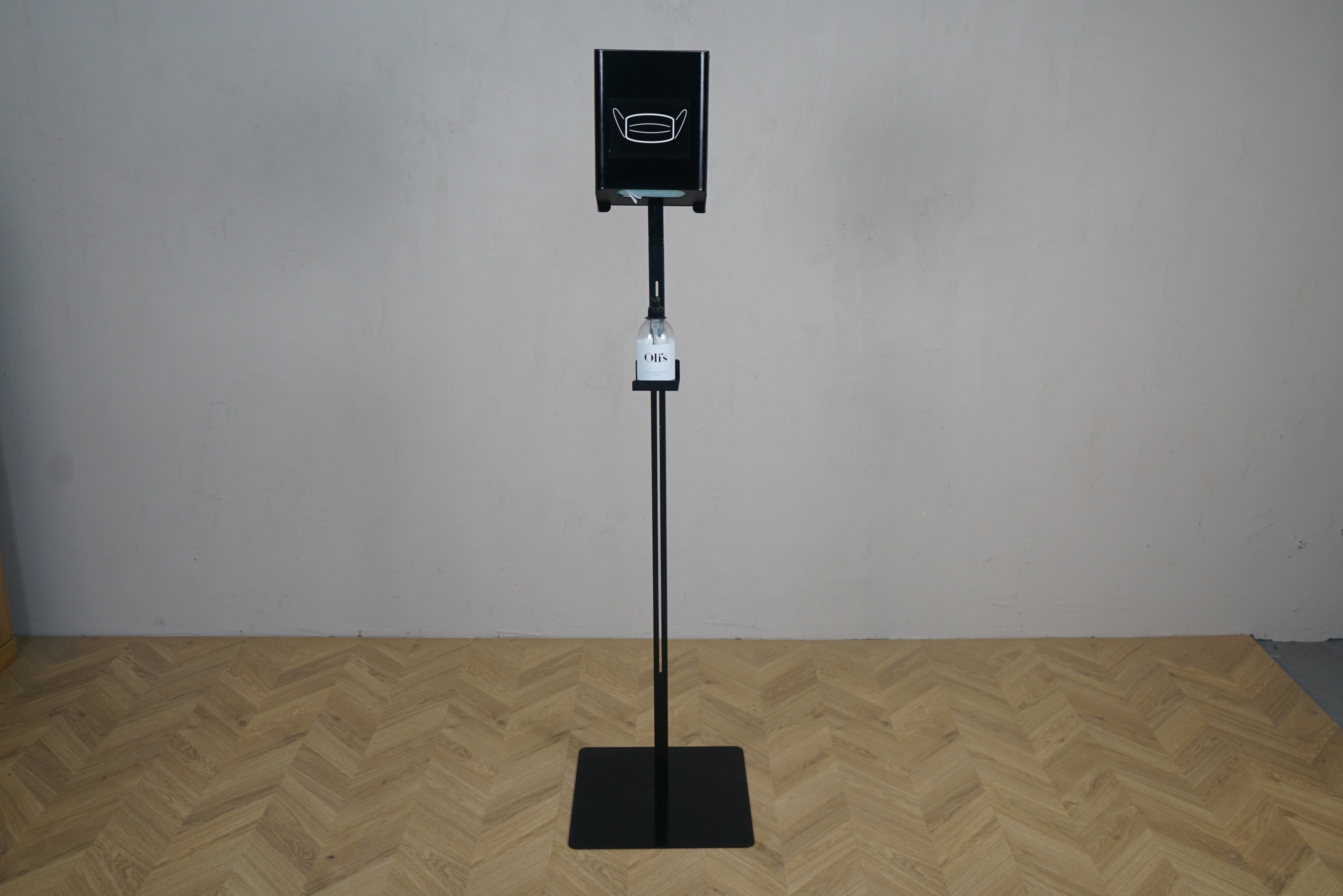 Sort stander til håndsprit og masker – frontvisning